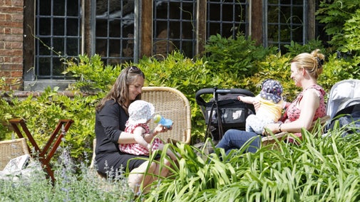 Visitors with babies sitting on the terrace outside the house at Goddards in Yorkshire